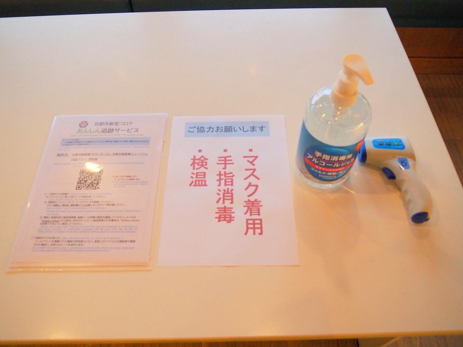 受付の様子<br>手指消毒液の設置、体温測定のほか、京都市あんしん追跡サービスも表示して来場者に推奨